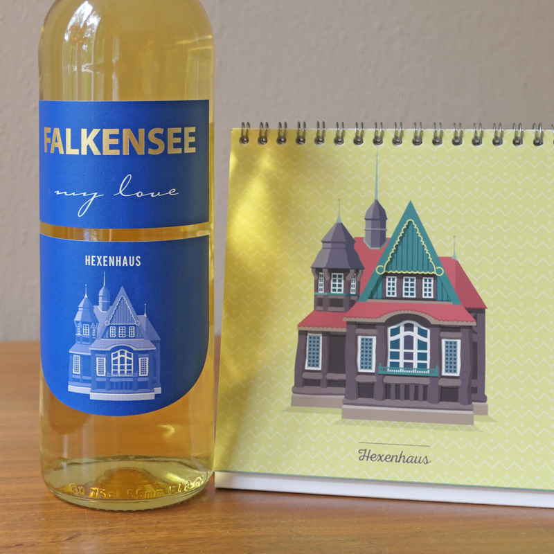 Weinflasche mit Etikett „Falkensee – my love“ und Tischkalender mit Architektur-Illustration des Hexenhauses – Design: Isabel Gewecke.